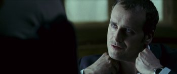 Movie still from “The Orphanage” (2007), directed by J.A. Bayona – A person wearing a suit and tie; Close Up shot, Over the shoulder angle