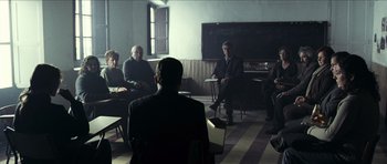 Movie still from “The Orphanage” (2007), directed by J.A. Bayona – A group of people sitting in a room; Wide shot, High angle