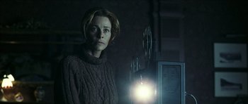 Movie still from “The Orphanage” (2007), directed by J.A. Bayona – A woman standing in front of a computer monitor; Medium shot, Low angle