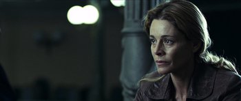 Movie still from “The Orphanage” (2007), directed by J.A. Bayona – A person sitting in a room; Close Up shot, Over the shoulder angle