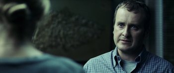 Movie still from “The Orphanage” (2007), directed by J.A. Bayona – A person sitting in a room; Close Up shot, Over the shoulder angle