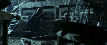 Movie still from “The Orphanage” (2007), directed by J.A. Bayona – A person sitting on a couch in a room; Wide shot, Low angle