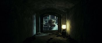 Movie still from “The Orphanage” (2007), directed by J.A. Bayona – A woman looking into a mirror in a dark room; Wide shot, Low angle