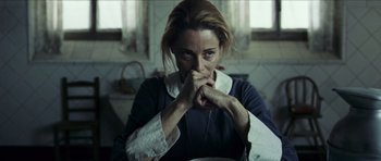 Movie still from “The Orphanage” (2007), directed by J.A. Bayona – A woman is sitting in a kitchen with her hands under her chin; Close Up shot, Low angle