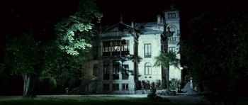 Movie still from “The Orphanage” (2007), directed by J.A. Bayona – A building that has a tree in front of it; Extreme Wide shot, Low angle