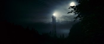 Movie still from “The Orphanage” (2007), directed by J.A. Bayona – A light shining on the top of a light house at night; Extreme Wide shot, Low angle