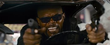 Movie still from “The Other Guys” (2010), directed by Adam McKay – A man in a leather jacket and sunglasses driving a car; Close Up shot, Low angle