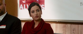 Movie still from “The Other Guys” (2010), directed by Adam McKay – A woman sitting in a chair wearing a red shirt; Close Up shot, Over the shoulder angle