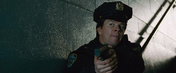 Movie still from “The Other Guys” (2010), directed by Adam McKay – A police officer is holding a gun in his hand; Close Up shot, Low angle