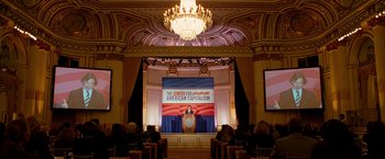 Movie still from “The Other Guys” (2010), directed by Adam McKay – A crowd of people sitting in front of a podium; Extreme Wide shot, High angle