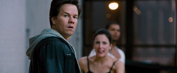 Movie still from “The Other Guys” (2010), directed by Adam McKay – A man and a woman standing next to each other in front of another man; Close Up shot, Over the shoulder angle