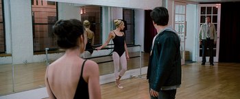 Movie still from “The Other Guys” (2010), directed by Adam McKay – A woman in a leotard is standing in front of a mirror; Wide shot, Over the shoulder angle