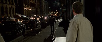 Movie still from “The Other Guys” (2010), directed by Adam McKay – A man walking down the sidewalk at night; Wide shot, Over the shoulder angle