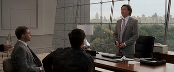 Movie still from “The Other Guys” (2010), directed by Adam McKay – Two men in suits are sitting in front of a large window; Medium shot, Over the shoulder angle