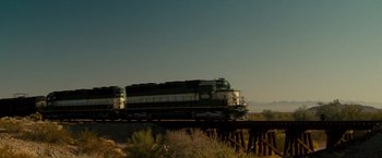 Movie still from “The Other Guys” (2010), directed by Adam McKay – A train traveling across a bridge over a river; Extreme Wide shot, Low angle