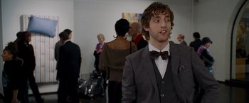Movie still from “The Other Guys” (2010), directed by Adam McKay – A man in a suit and bow tie standing in front of a group of people; Medium shot, Over the shoulder angle