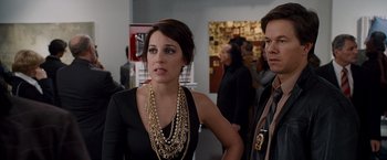Movie still from “The Other Guys” (2010), directed by Adam McKay – A woman in a black dress and a man in a black suit; Medium shot, Over the shoulder angle