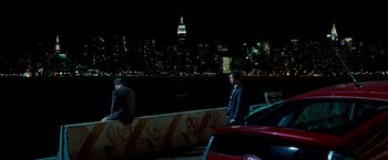 Movie still from “The Other Guys” (2010), directed by Adam McKay – Two men standing on the side of a boat in front of a city skyline at night; Wide shot, Over the shoulder angle