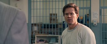 Movie still from “The Other Guys” (2010), directed by Adam McKay – A man standing in front of a cage in a jail cell; Close Up shot, Over the shoulder angle