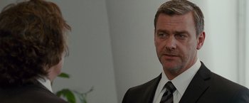 Movie still from “The Other Guys” (2010), directed by Adam McKay – A person wearing a suit and tie; Close Up shot, Over the shoulder angle
