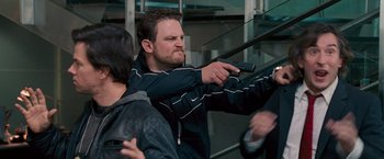 Movie still from “The Other Guys” (2010), directed by Adam McKay – A man holding a gun while standing next to another man; Medium shot, Over the shoulder angle