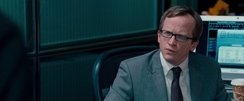 Movie still from “The Other Guys” (2010), directed by Adam McKay – A man in a suit and tie sitting in a chair; Close Up shot, Over the shoulder angle