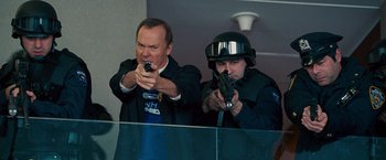 Movie still from “The Other Guys” (2010), directed by Adam McKay – A man and a man in a black suit holding guns; Medium shot, Over the shoulder angle