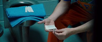 Movie still from “The Other Guys” (2010), directed by Adam McKay – A person holding a piece of paper in their hand; Extreme Close Up shot, Overhead angle