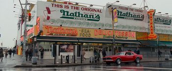 Movie still from “The Other Guys” (2010), directed by Adam McKay – People walking on the sidewalk in front of a restaurant; Extreme Wide shot, Low angle