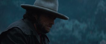 Movie still from “The Outlaw Josey Wales” (1976), directed by Clint Eastwood – A man with a cowboy hat on looking into the distance; Close Up shot, Over the shoulder angle