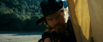 Movie still from “The Outlaw Josey Wales” (1976), directed by Clint Eastwood – A man with a beard wearing a hat and holding a gun; Close Up shot, Low angle