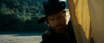 Movie still from “The Outlaw Josey Wales” (1976), directed by Clint Eastwood – A man with a beard wearing a black hat; Close Up shot, Low angle