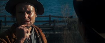 Movie still from “The Outlaw Josey Wales” (1976), directed by Clint Eastwood – An older man wearing a cowboy hat near a body of water; Close Up shot, Over the shoulder angle