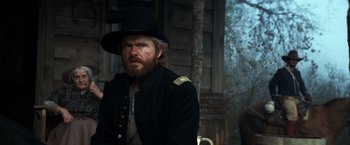 Movie still from “The Outlaw Josey Wales” (1976), directed by Clint Eastwood – A man wearing a black hat and a black jacket; Close Up shot, Over the shoulder angle