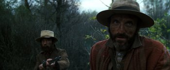 Movie still from “The Outlaw Josey Wales” (1976), directed by Clint Eastwood – A man in a cowboy hat is holding a gun; Close Up shot, Over the shoulder angle
