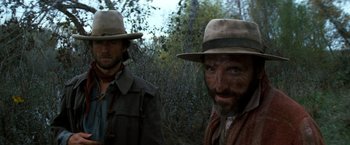 Movie still from “The Outlaw Josey Wales” (1976), directed by Clint Eastwood – A man with a beard and a hat and a man with a beard and a hat; Close Up shot, Low angle