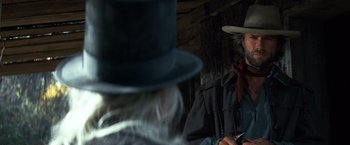 Movie still from “The Outlaw Josey Wales” (1976), directed by Clint Eastwood – A man in a top hat and a man with a long beard; Close Up shot, Over the shoulder angle