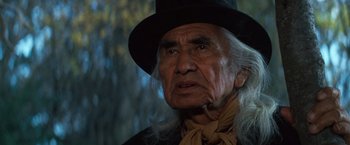 Movie still from “The Outlaw Josey Wales” (1976), directed by Clint Eastwood – An old man with long white hair wearing a black hat; Close Up shot, Low angle