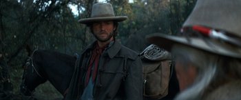 Movie still from “The Outlaw Josey Wales” (1976), directed by Clint Eastwood – A man with a hat and a bag on his back; Close Up shot, Low angle