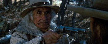Movie still from “The Outlaw Josey Wales” (1976), directed by Clint Eastwood – An old man with a hat is holding a gun; Close Up shot, Low angle