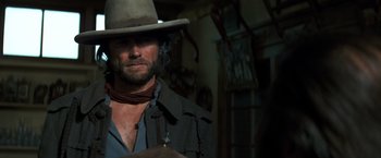 Movie still from “The Outlaw Josey Wales” (1976), directed by Clint Eastwood – A man with a cowboy hat and a beard; Close Up shot, Over the shoulder angle