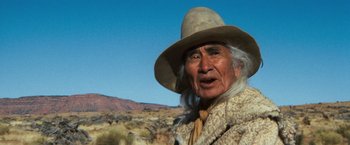 Movie still from “The Outlaw Josey Wales” (1976), directed by Clint Eastwood – An older man in a hat and a fur coat; Close Up shot, Low angle