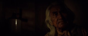 Movie still from “The Outlaw Josey Wales” (1976), directed by Clint Eastwood – An old man with long white hair is looking at the camera; Close Up shot, Over the shoulder angle