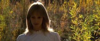 Movie still from “The Outlaw Josey Wales” (1976), directed by Clint Eastwood – A woman in a white dress standing in front of trees; Close Up shot, Low angle