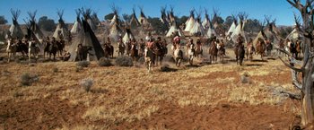 Movie still from “The Outlaw Josey Wales” (1976), directed by Clint Eastwood – A group of people riding horses through a field; Extreme Wide shot, High angle
