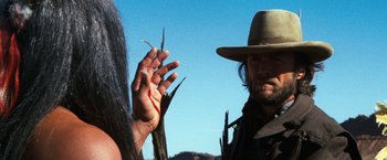 Movie still from “The Outlaw Josey Wales” (1976), directed by Clint Eastwood – A man with long hair and a cowboy hat; Close Up shot, Over the shoulder angle