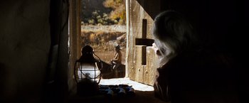 Movie still from “The Outlaw Josey Wales” (1976), directed by Clint Eastwood – An old woman sitting at a table looking out of a window; Wide shot, Over the shoulder angle