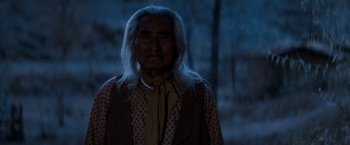 Movie still from “The Outlaw Josey Wales” (1976), directed by Clint Eastwood – An old man with long white hair standing in the dark; Close Up shot, Low angle