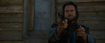 Movie still from “The Outlaw Josey Wales” (1976), directed by Clint Eastwood – A man holding a gun in his right hand; Close Up shot, Low angle