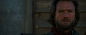 Movie still from “The Outlaw Josey Wales” (1976), directed by Clint Eastwood – A person with long hair and a beard; Close Up shot, Over the shoulder angle